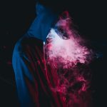 man in black hoodie smoking